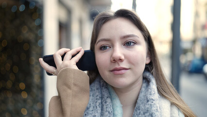 Sticker - Young blonde woman smiling confident listening audio message by the smartphone at street