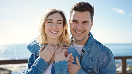 Canvas Print - Man and woman couple smiling confident hugging each other at seaside