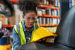 © Supachai - Young African American female worker forklift driver relaxing after work in industry factory logistic shipping warehouse.