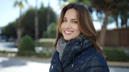 Wall Mural - Young beautiful hispanic woman smiling confident standing at street