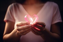 A Close - Up Photography Focusing On A Woman's Hands Forming A Heart Shape With A Pink Ribbon Against A Soft Pink Background. Breast Cancer. Generative AI