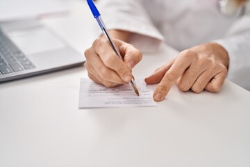 Poster - Young beautiful hispanic woman doctor writing on covid certificate card at clinic