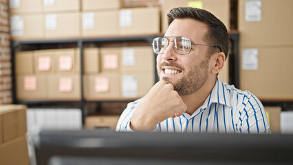 Wall Mural - Young hispanic man ecommerce business worker sitting on table thinking at office