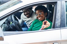 African american man and woman couple holding key of new car at street