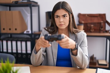 Poster - Hispanic woman working at the office playing video games skeptic and nervous, frowning upset because of problem. negative person.