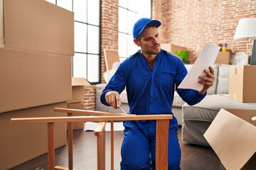 Canvas Print - Young hispanic man technician repairing chair at new home