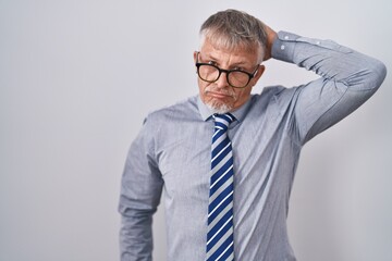 Poster - Hispanic business man with grey hair wearing glasses confuse and wondering about question. uncertain with doubt, thinking with hand on head. pensive concept.