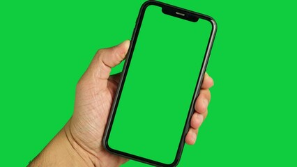 Hand holding mobile phone, green screen smartphone, chroma key phone, using phone with green screen 