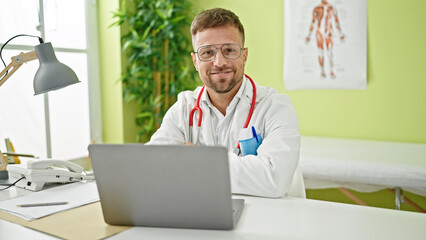 Poster - Young man doctor using laptop working at clinic