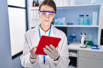 Sticker - Young caucasian woman scientist using touchpad at laboratory