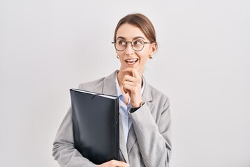 Poster - Young caucasian woman wearing business clothes and glasses thinking worried about a question, concerned and nervous with hand on chin