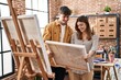 © Krakenimages.com - Mand and woman artist couple smiling confident holding draw at art studio