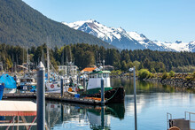 Fishing Boats Moored In The Docks In Sitka Alaska With Scenic Snowcapped Mountains In The Background 