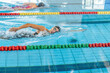 © 24K-Production - Professional female swimmer swimming the front crawl stroke. Freestyle competition concept.