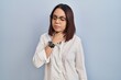 © Krakenimages.com - Young hispanic woman standing over white background touching painful neck, sore throat for flu, clod and infection