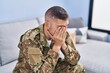 © Krakenimages.com - Young hispanic man army soldier sitting on sofa stressed at home