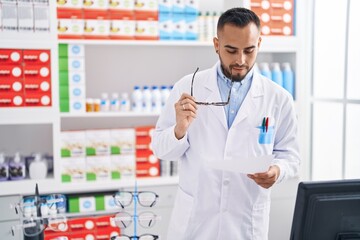 Canvas Print - Young hispanic man pharmacist reading prescription at pharmacy