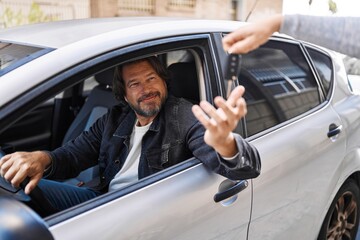 Sticker - Middle age man smiling confident holding key of new car at street