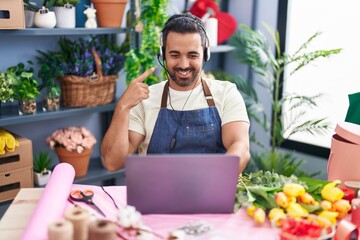 Poster - Hispanic man with beard working at florist shop using laptop smiling happy pointing with hand and finger