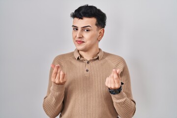 Poster - Non binary person standing over isolated background doing money gesture with hands, asking for salary payment, millionaire business