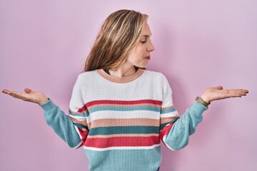 Poster - Young blonde woman standing over pink background smiling showing both hands open palms, presenting and advertising comparison and balance