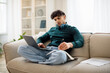 © Prostock-studio - Middle Eastern Guy Studying With Laptop At Home Taking Notes