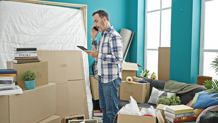 Sticker - Middle age man talking on smartphone using touchpad at new home