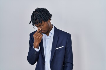 Sticker - Young african man with dreadlocks wearing business jacket over white background tired rubbing nose and eyes feeling fatigue and headache. stress and frustration concept.