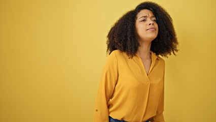 African american woman looking for over isolated yellow background