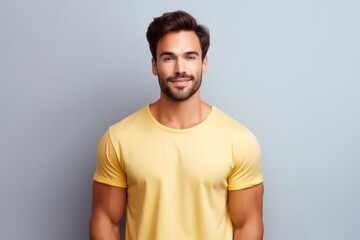 Wall Mural - Portrait of a muscular handsome guy wearing a plain yellow t-shirt, isolated on a pastel background. Generative AI illustration.