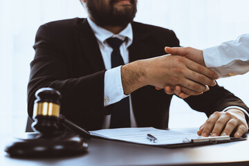 Wall Mural - Closeup lawyer or attorneys colleagues handshake after successful legal discussing on contract agreement for lawsuit to advocate resolves dispute in court ensuring trustworthy partner. Equilibrium