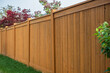 Nice wooden fence around house. Wooden fence with green lawn. Street photo