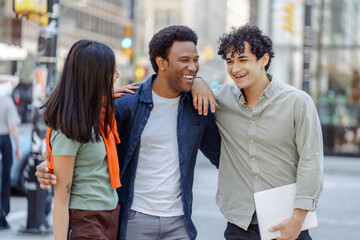 Wall Mural - Multiracial young people talking on street near university campus smiling. Planning startup together