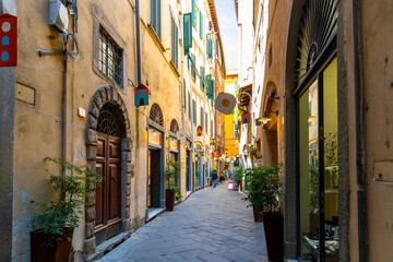 A picturesque narrow alley or street of shops, businesses and apartments in the historic center of Lucca, Italy in the Tuscany region.