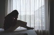 © Farknot Architect - Silhouette of a woman sitting and crying on a bed in bedroom