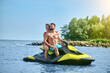 © zinkevych - Beautiful couple sitting on jet ski enjoying honey moon at resort, spending active time.