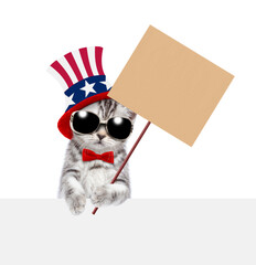 Poster - Cute kitten wearing like Uncle Sam looks above empty white banner and shows empty placard. isolated on white background