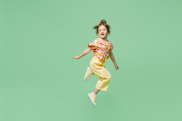 Wall Mural - Full body sideways happy little child kid girl 6-7 years old wear casual clothes jump high raise up hands isolated on plain pastel green background studio. Mother's Day love family lifestyle concept.