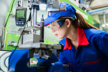 Wall Mural - A female diesel engine mechanic in a blue uniform is working at the garage. Inspect and maintain the fuel pressure booster pump system and common rail injectors.