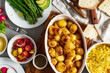 © kucherav - Vegetarian home dinner table with healthy food. Set of various food from baked new potatoes, vegetables and salads top view