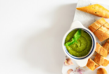 Canvas Print - Homemade pesto sauce with fresh baguette on a white background top view