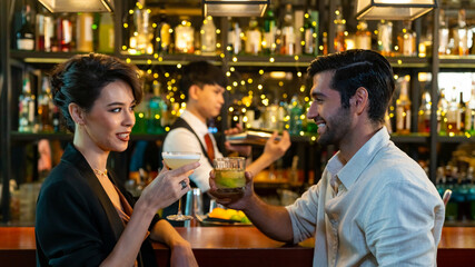 Wall Mural - Caucasian man and woman flirting each other while hangout nightlife party at restaurant bar. Attractive female have romantic dating with boyfriend celebrating holiday event together at nightclub