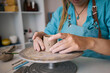 © Westend61 - Craftswoman sculpting clay cup on pottery wheel at workshop