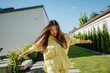 © Westend61 - Smiling woman with arms outstretched enjoying in backyard