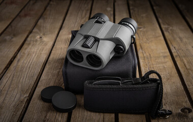 Wall Mural - Modern binoculars. An optical instrument for observation at long distances. Wooden back