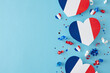 Party concept for celebrating Bastille Day on July 14th. Top view arrangement of hearts in patriotic colors, confetti on light blue background with empty space for ad or text