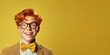 Happy ginger teenage boy with big eyeglasses and bow ties. Isolated on solid yellow background 