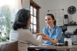 © Natee Meepian - Senior care, healthcare insurance and caregiver woman sitting with elderly woman patient laughing and talking while enjoying retirement home. Old lady and female nurse hospice with health check form