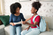 Daughter delivers school report card to mother in living room