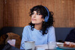 © Johnér - Young woman with dark curly hair listening to music on headphones